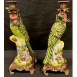 A pair of reproduction Meissen style candlesticks, modelled as parrots, gilt metal mounted, 35cm