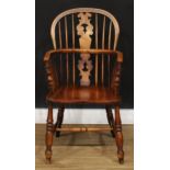 A 19th century elm Windsor elbow chair, hoop back, shaped and pierced splat, one-piece mid-rail,