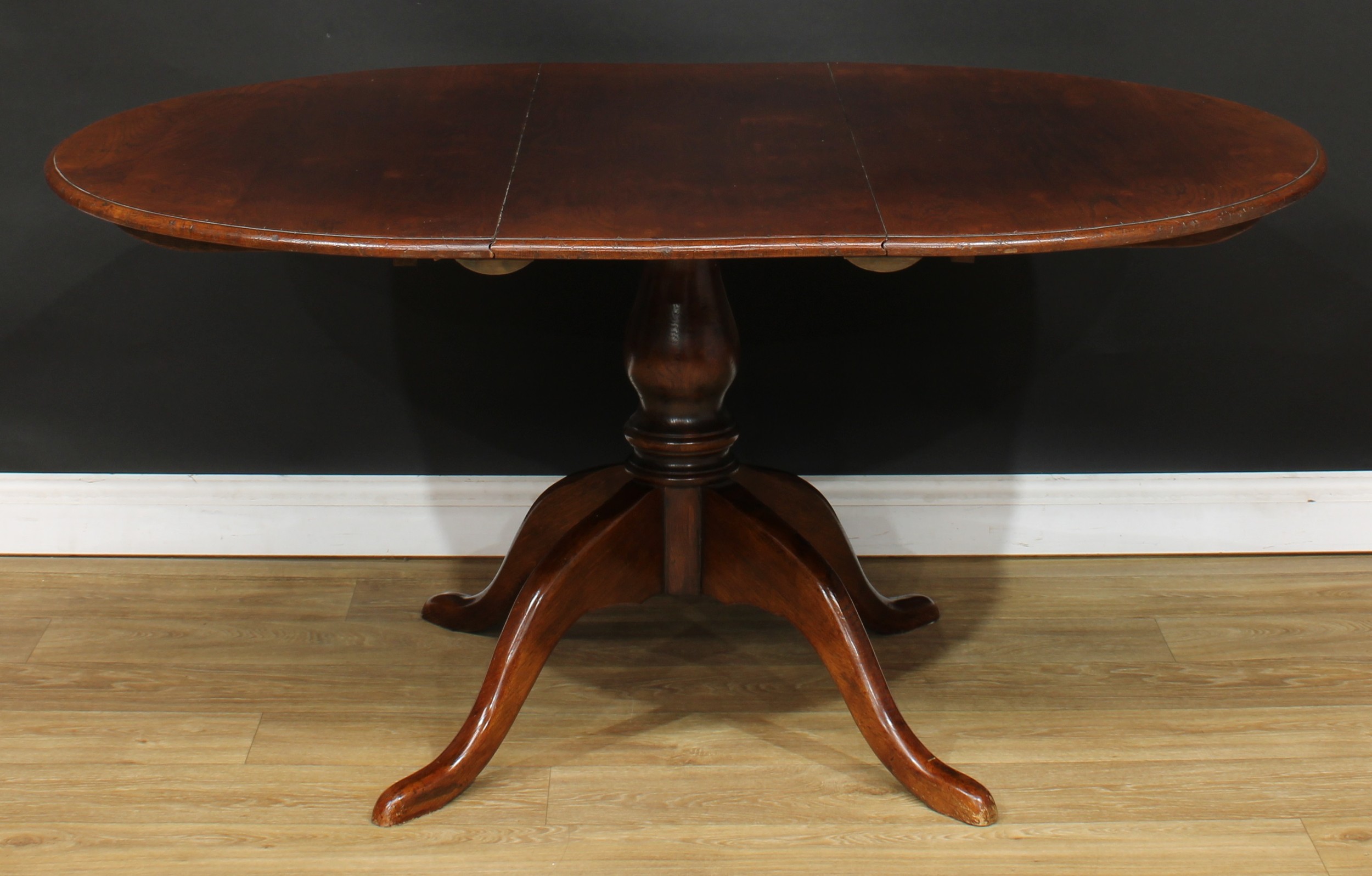 An oak single pillar dining table, possibly Titchmarsh & Goodwin, the top with one additional