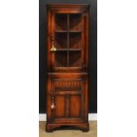 An oak floor-standing corner cabinet, possibly Titchmarsh & Goodwin, 179cm high, 61cm wide, 33cm