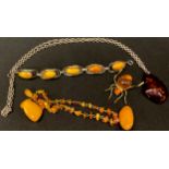 A butterscotch amber and silver bracelet; a spider brooch; an amber and silver pendant