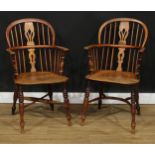 A near pair of 19th century Windsor elbow chairs, each with a low hoop back, shaped and pierced