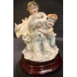 An Italian B Merli of Florence table lamp, the moulded resin base with two children and a dog,