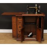 An early 20th century Singer sewing machine, F593326, converted to electricity, in oak cabinet,