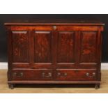 A late 18th century oak mule chest, hinged top above four raised and fielded panels and a pair of