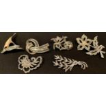 A sterling silver openwork filigree brooch; a silver brooch; three other brooches, enamel ship,