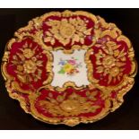 A Meissen shaped circular cabinet plate, printed with summer flowers on a burgundy red ground,