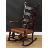An Arts & Crafts rocking chair, the spindle-centred ladderback applied with leather panels