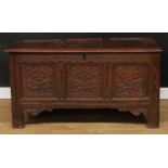 An early 18th century oak blanket chest, hinged three panel top, the frieze and front panels