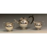 A silver three piece globular tea service, pierced gallery, ebonised scroll handle, 14cm high, James