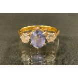 A diamond and pale purply blue dress ring, central oval pale purply blue stone possibly tanzanite,