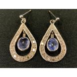 A pair of diamond and tanzanite pear drop earrings, central oval pale tanzanite within a thirteen