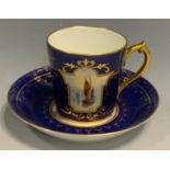 A Royal Crown Derby cabinet cup, painted by W.E.J. Dean, within a shaped cartouche, on a blue