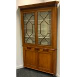 A George III oak floorstanding corner cabinet, moulded cornice above two astragal glazed doors,