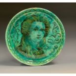 A Della Robbia charger, painted by Harold Rathbone, with a portrait of Enid Woodhouse, in black,