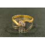 A diamond twist ring, inset with two coller set round brilliant cut diamonds, total estimated