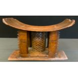 A 19th century Ghanaian Ashanti stool or seat, arched rectangular seat with four carved supports and