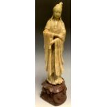 A Chinese celadon soapstone carving, of Guanyin, well-carved with a serene face, wearing flowing