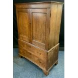 A George III low oak linen press, c.1800 moulded cornice above two panelled doors, the interior with