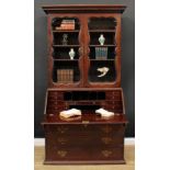 A 19th century mahogany bureau bookcase, dentil cornice above a pair of glazed doors enclosing three