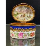 A large French oval trinket box and cover, the cover painted with flower sprays within a gilt