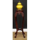 A Chinese hardwood jardiniere stand, circular top with inset soapstone panel, carved throughout with