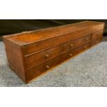 A 19th century oak table top chest, c.1820 hinged top, above three rows of six drawers 23cm high