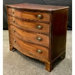 A George III mahogany and satinwood strung serpentine chest, of four long drawers, the top drawer