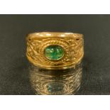 An emerald signet ring, open cast Celtic knot crest inset with a single oval cabochon emerald,