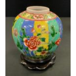 A Chinese ovoid ginger jar, painted in polychrome with peonies on a yellow, green and blue banded