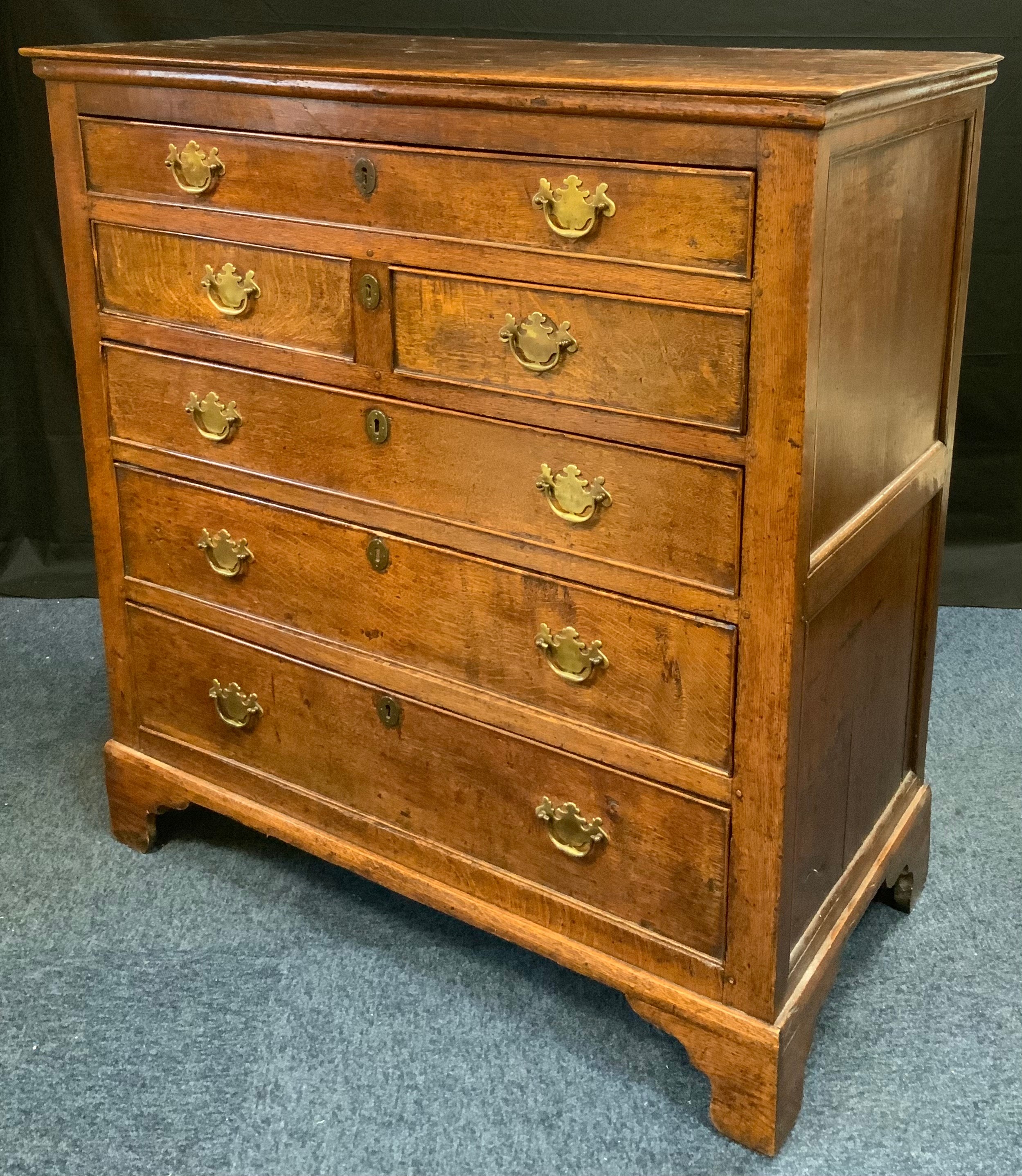 A 19th century oak chest, c.1800 of one long, two short and three long graduated drawers, bracket