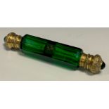 A Victorian emerald glass double-ended scent bottle, faceted reservoir, the domed hinged brass