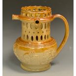 A 19th century brown salt glazed stoneware puzzle jug, pierced with stylised flowerhead and