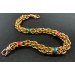 An 18ct gold fancy link bracelet divided by five alternate enamelled bands in emerald green and ruby