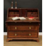 A George III mahogany crossbanded oak bureau, fall front enclosing a door, small drawers,