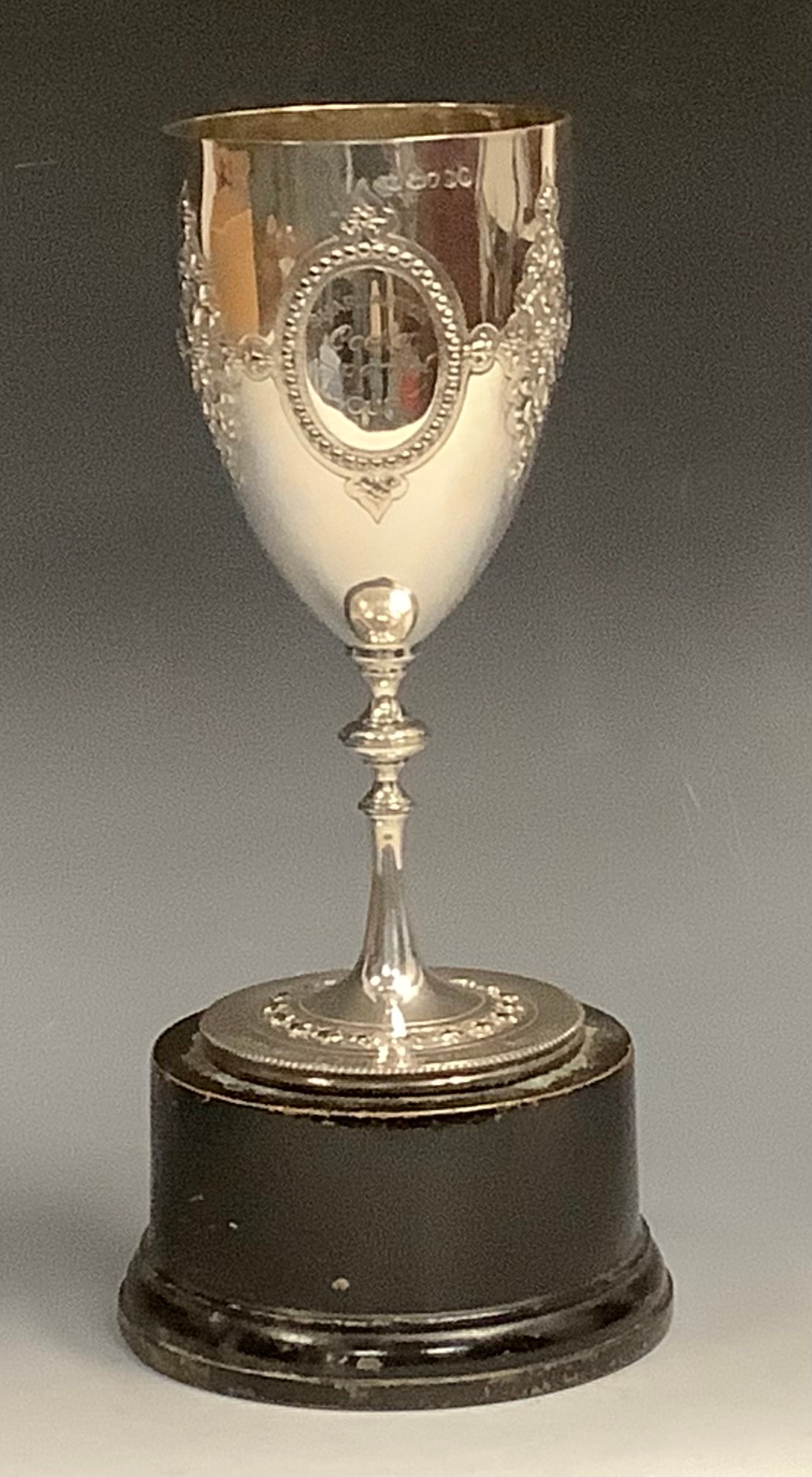 A Victorian pedestal goblet, embossed with oval cartouches and scrolls, knopped stem, spreading