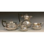 A silver half fluted boat shaped three piece tea service, comprising teapot, milk jug and sugar