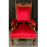 A late Victorian mahogany library chair, carved cresting rail, open arms with pierced splats, red