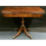 A Reprodux type mahogany games table, turned column, reeded legs, brass paw feet, 76cm high, 85cm