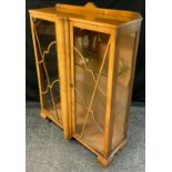 An Art Deco walnut two door display cabinet, ornate cloud crest doors, 118cm, high, 88cm wide, 30.