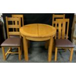 An oak circular extending dining table with a set of four oak dinning chairs (5)