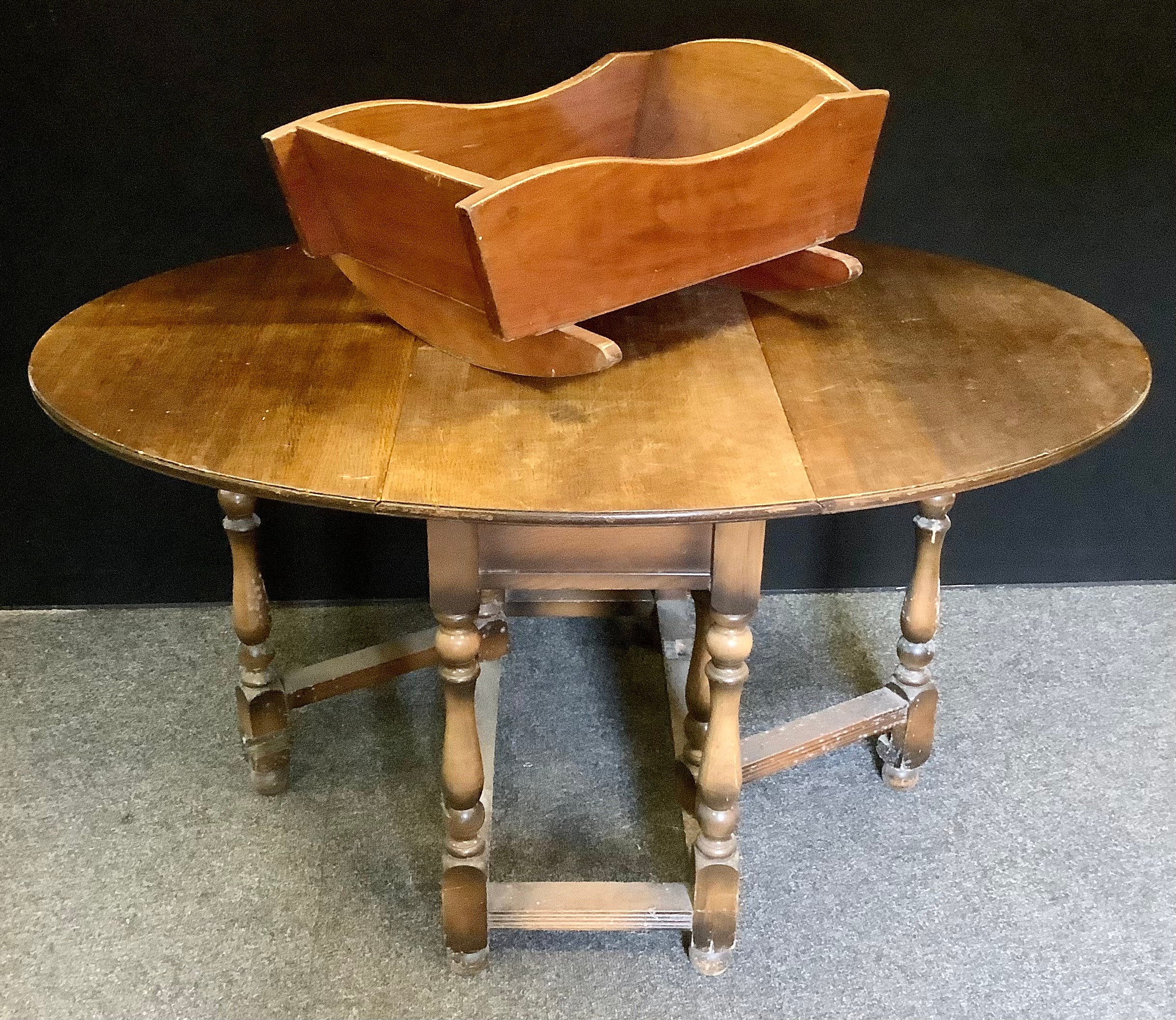 An early 20th century oak drop-leaf dining table; a mahogany crib, (2).