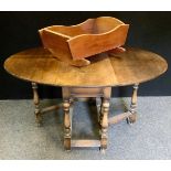 An early 20th century oak drop-leaf dining table; a mahogany crib, (2).