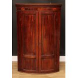 A George III mahogany bow front corner cabinet, dentil cornice above a marquetry frieze inlaid