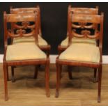 A set of four Post-Regency mahogany dining chairs, each with a scroll carved mid-rail applied with