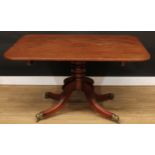 A mahogany breakfast table, rounded rectangular tilting top, turned pillar, hipped sabre legs, brass