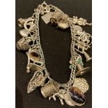 A silver charm bracelet, containing approx. 27 charms