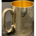 An Elizabeth II silver mug of plain design, loop handle, gilt interior, 9cm, London 1960, 196g