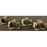 A set of four American EPNS napkin rings, each mounted with a pair of cats in relief, by Reed and