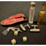 An early 20th century brass novelty dice box, as a bottle; a pair of silver bullet cufflinks; a